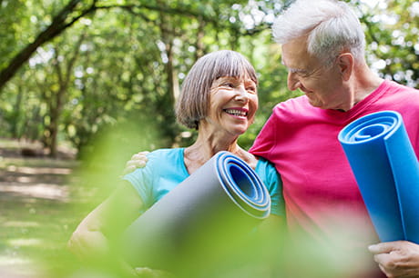 Senior man and woman doing yoga in a park